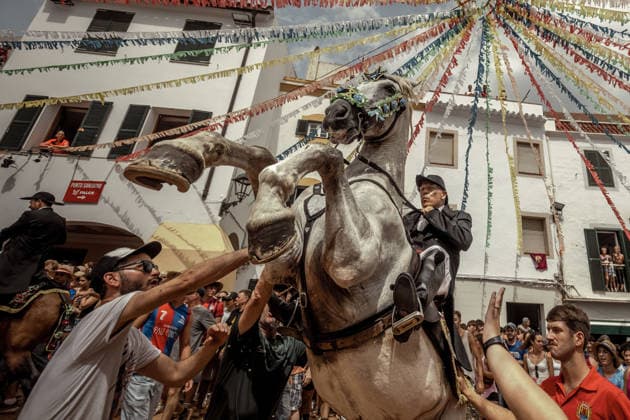 August 24, 2026, Ferreries, Menorca Balearic Islands, Spain: A caixer, or horse rider, rears his horse amid a cheering crowd during the traditional Jaleo at the Sant Bartomeu Festival in Ferreries. Ferreries Spain  - ZUMAo105 20260824_fap_o105_020 Copyright: xMatthiasxOesterlex
