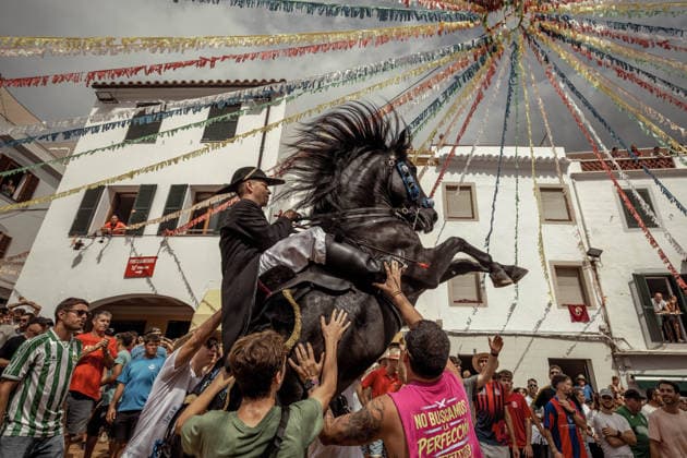 August 24, 2026, Ferreries, Menorca Balearic Islands, Spain: A caixer, or horse rider, rears his horse amid a cheering crowd during the traditional Jaleo at the Sant Bartomeu Festival in Ferreries. Ferreries Spain  - ZUMAo105 20260824_fap_o105_023 Copyright: xMatthiasxOesterlex
