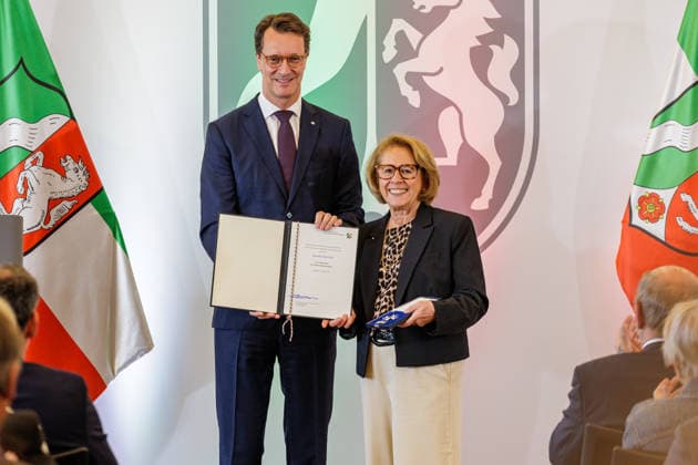 24.08.2026. Düsseldorf. (l-r) NRW-Ministerpräsident Hendrik Wüst und Monika Bartsch bei der Verleihung des Verdienstordens des Landes Nordrhein-Westfalen anlässlich des 80. Landesgeburtstages. Monika Bartsch hat als Oberbürgermeisterin von Mönchengladbach von 1998 bis 2004 die Stadtentwicklung entscheidend mitgeprägt. Mit der Bewerbung der Stadt als Austragungsort der Olympischen Spiele 2012 und der erfolgreichen Ausrichtung der Hockey-WM hat sie wichtige Impulse für den Sportstandort gesetzt. Seit rund 20 Jahren engagiert sie sich als Vorsitzende der Mönchengladbacher Tafel für die Versorgung von inzwischen rund eintausend Haushalten und für zahlreiche soziale Projekte. Düsseldorf Staatskanzlei Nordrhein-Westfalen Deutschlan