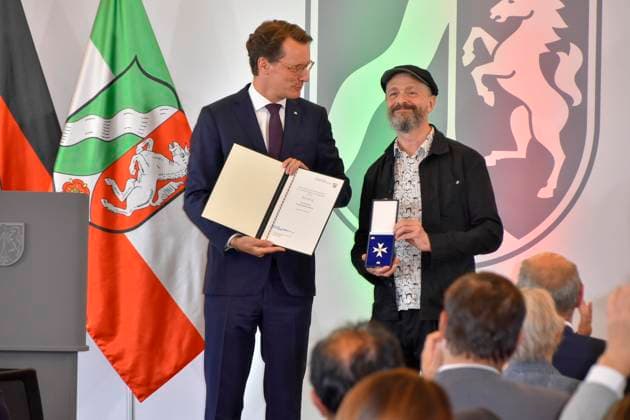 ABB NRWORDEN- Hendrik Wüst Wuest MP NRW mit Ralf König Koenig Comic zeichner bei der Verleihung des Verdienstorden und der Urkunde des Landes Nordrhein-Westfalen in der Staatskanzlei am 24.AUGUST 2026 in Duesseldorf NRW Deutschland *** ABB NRWORDEN Hendrik Wüst Wuest, MP for North Rhine-Westphalia, with Ralf König Koenig, comic artist, at the ceremony to present the Order of Merit and the certificate from the State of North Rhine-Westphalia at the State Chancellery on August 24, 2026, in Düsseldorf, North Rhine-Westphalia, Germany