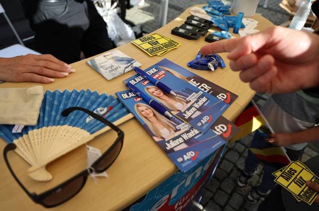Wahlkampf der AfD zur Landtagswahl in Sachsen-Anhalt 24.08.2026, Naumburg, Wahlkampf der AfD auf dem Naumburger Marktplatz, am 06.09.2026 wird der neue Landtag in Sachsen-Anhalt gewaehlt im Bild: Merchandise-Artikel der AfD neben Wahl-Flyern von Juliane Waehler (AfD) *** AfD campaign for the state election in Saxony-Anhalt, August 24, 2026, Naumburg, AfD campaign event on Naumburg’s market square; on September 6, 2026, the new state parliament of Saxony-Anhalt will be elected. Pictured: AfD merchandise next to campaign flyers by Juliane Waehler, AfD