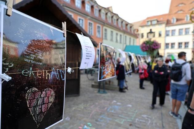 Wahlkampf der AfD zur Landtagswahl in Sachsen-Anhalt 24.08.2026, Naumburg, Wahlkampf der AfD auf dem Naumburger Marktplatz, am 06.09.2026 wird der neue Landtag in Sachsen-Anhalt gewaehlt im Bild: Gegenveranstaltung auf dem Holzmarkt - Fotos von Kreidebildern gegen die AfD sind an einer Leine aufgehangen - hier kann man efelhAFD lesen *** AfD campaign for the state election in Saxony-Anhalt, August 24, 2026, Naumburg, AfD campaign rally on Naumburg’s market square; on September 6, 2026, the new state parliament of Saxony-Anhalt will be elected. Pictured: a counter-demonstration on the Holzmarkt; photos of chalk drawings opposing the AfD are hung on a rope—here you can read efelhAFD.