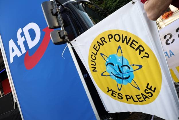 Wahlkampf der AfD zur Landtagswahl in Sachsen-Anhalt 24.08.2026, Naumburg, Wahlkampf der AfD auf dem Naumburger Marktplatz, am 06.09.2026 wird der neue Landtag in Sachsen-Anhalt gewaehlt im Bild: neben der Buehne haelt jemand ein Transparent mit der Aufschrift Nuclear Power? Yes Please *** AfD campaign for the state election in Saxony-Anhalt, August 24, 2026, Naumburg, AfD campaign rally on Naumburg’s market square; on September 6, 2026, the new state parliament of Saxony-Anhalt will be elected. In the photo, next to the stage, someone is holding a banner reading Nuclear Power Yes Please.