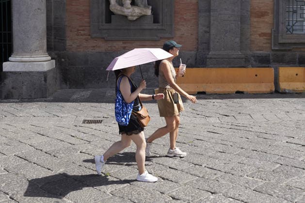The fifth wave of the African heatwave in Naples NAPLES, ITALY - AUGUST 25: A woman uses an umbrella to shield herself from the sun during the African heatwave in Naples on August 25, 2026. The fifth wave of the African heatwave is currently underway in Central-Southern Italy, with temperatures reaching 40-45 degrees. Eliano Imperato Anadolu Naples Italy. Editorial use only. Please get in touch for any other usage.  Copyright: x2026xAnadoluxElianoxImperatox