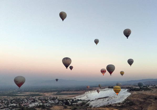 News Bilder des Tages (260825) -- DENIZLI, Aug. 25, 2026 -- A drone photo taken on Aug. 25, 2026 shows hot air balloons fly over Pamukkale in Denizli, T¨¹rkiye. ( Handout via Xinhua) T?RKIYE-DENIZLI-HOT AIR BALLOONS MustafaxKaya 