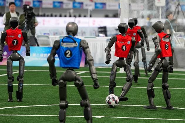(260825) -- BEIJING, Aug. 25, 2026 -- The robot (2nd R) of Tsinghua Vulcan Team competes during the football 5v5 - Large Robot Group match of the 2nd World Humanoid Robot Games in Beijing, capital of China, Aug. 25, 2026. ) (SP)CHINA-BEIJING-WORLD HUMANOID ROBOT GAMES (CN) JuxHuanzong 