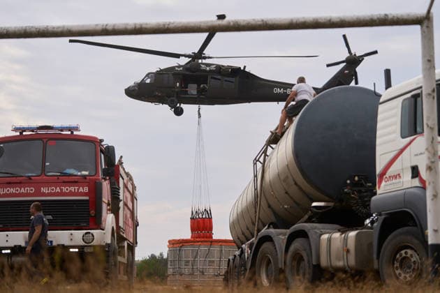 News Bilder des Tages August 25, 2026, Susara, Vojvodina, Serbia: 2026825, Susara, Serbia - Two Sikorsky UH-60 Black Hawk helicopters are deployed to the village of Susara to help battle the severe wildfires devastating the Deliblato Sands (Deliblatska Pescara) Special Nature Reserve, refilling their buckets from a large portable water tank placed on a local football pitch. Susara Serbia - ZUMAd223 20260825_zip_d223_004 Copyright: xMarkoxDimicx