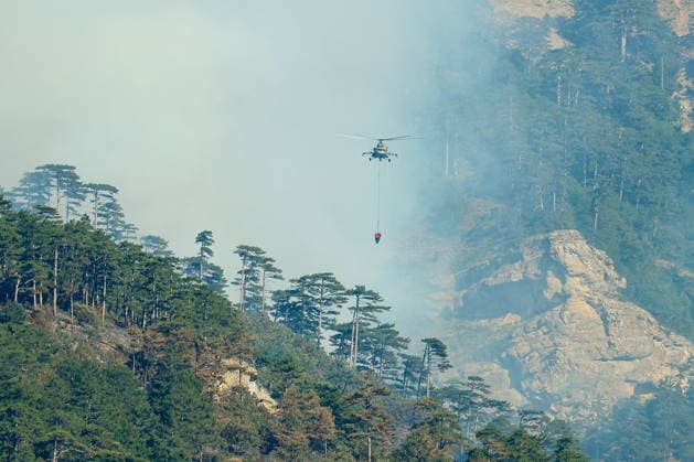 RUSSIA, REPUBLIC OF CRIMEA - AUGUST 26, 2026: A helicopter battles a wildfire in the mountains near Yalta. The blaze, which has been burning for nearly a week, has been declared a regional nature emergency. Maxim Churusov TASS  96651274