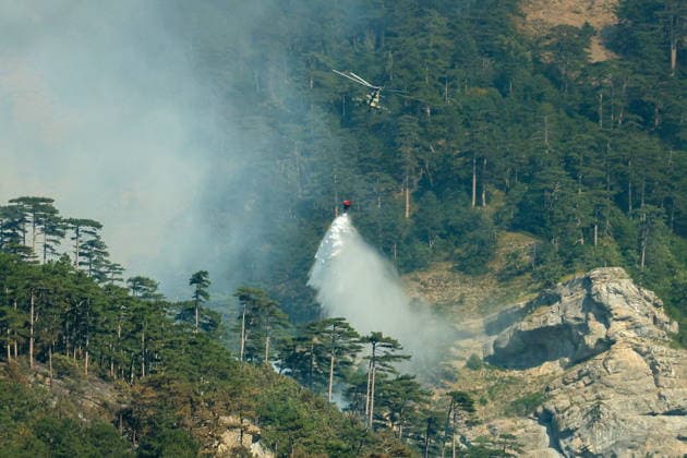 RUSSIA, REPUBLIC OF CRIMEA - AUGUST 26, 2026: A helicopter battles a wildfire in the mountains near Yalta. The blaze, which has been burning for nearly a week, has been declared a regional nature emergency. Maxim Churusov TASS  96651276
