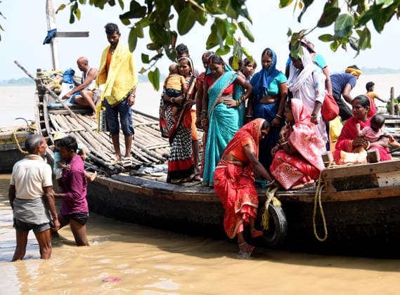 People move to a safer place as the Ganga River s water level rises in Bihar Patna, Aug 26 (ANI): A man and a woman carry their children as they arrive to a safer place by boat from the flood-affected area as the Ganga River s water level rises, in Patna on Wednesday. Patna Bihar India Copyright: xANIx ANI_20260826011