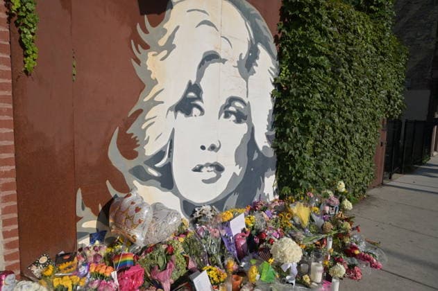 Flowers and candles left by Dolly Parton mural in Chicago CHICAGO, ILLINOIS, UNITED STATES - AUGUST 26: A view of flower bouquets, handwritten notes, and candles left by mourners at the base of the iconic Dolly Parton mural outside The Lytle House event venue in the Edgewater neighborhood in Chicago, Illinois, United States, on August 26, 2026. Fans and members of the community have transformed the local landmark into a growing memorial site to pay their respects following the passing of the country music legend, actress, and philanthropist at age 80. Jacek Boczarski Anadolu Illinois United States. Editorial use only. Please get in touch for any other usage. Copyright: x2026xAnadoluxJacekxBoczarskix