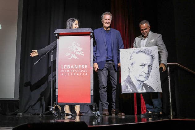 August 27, 2026: BRYAN BROWN C) receives a self portrait gift at the Lebanese Film Festival Australia 2026 Opening Night at the Bryan Brown Theatre on August 27, 2026 in Sydney, NSW Australia  - ZUMAa155 20260827_aaa_a155_072 Copyright: xChristopherxKhouryx