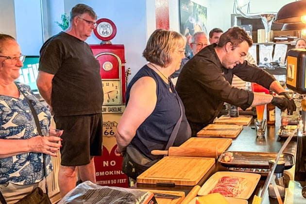 Joel Engelter demonstrates how to place the marinated chicken thighs on the grill rack. Büttelborn, August 27, 2026. Grillfürst BBQ Seminar