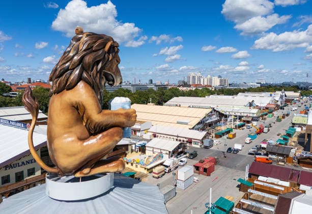 MUNICH, GERMANY - AUGUST 29, 2026: Oktoberfest Setup with Lion Statue and Beer Tents A large lion statue holding a beer stein overlooks the Theresienwiese during the setup phase of the 2026 Oktoberfest in Munich. Munich Germany *** MÜNCHEN, DEUTSCHLAND, 29. AUGUST 2026 Aufbau des Oktoberfestes mit Löwenstatue und Bierzelten Eine große Löwenstatue, die einen Bierkrug in der Hand hält, überragt die Theresienwiese während der Aufbauarbeiten für das Oktoberfest 2026 in München, Deutschland Copyright: xx
