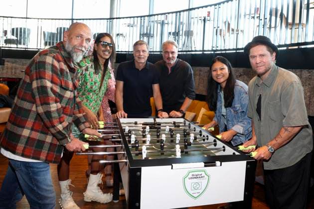 CNTV HERZKICKEN: Holger Stanislawski, Jorge Gonzalez, Belle La Donna, Thomas Helmer, Linh Tran, and Johannes Oerding at the foosball table during the press conference for the Charity Kicken mit Herz event at Restaurant Karo Paul im Bunker, Feldstrasse 27, on August 2026 in Hamburg, Germany