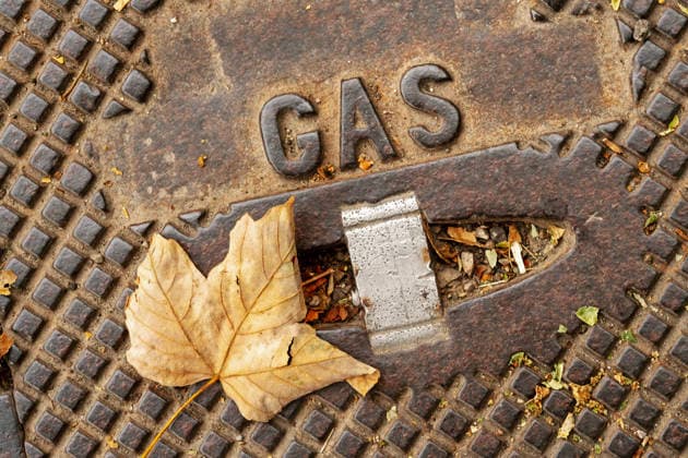 Gas manhole cover with an autumn leaf; the leaf rests on a manhole cover for gas lines; stock photo; Munich, September 2026; Germany, Mun