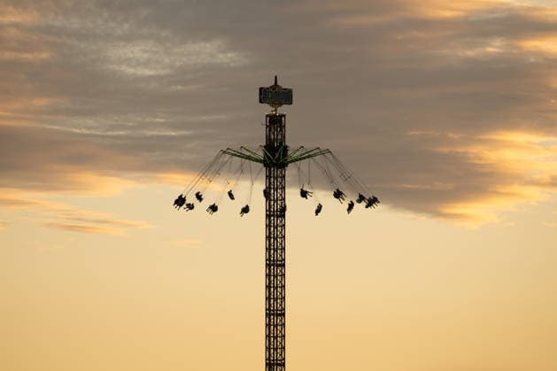 The Aeronaut fairground carousel can be seen as a silhouette in the evening light at the Glücksgefühle Festival at the Hockenheimring in Hockenheim, Baden-Württemberg, Germany