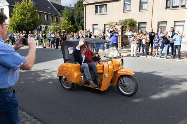 September 5, 2026, Movie premiere, Comrade Michael Ransburg wears a mask; actor Dr. Leisewitz pulls up and waves; Markneukirchen Harmonie Lichtspiele, Saxony, Germany