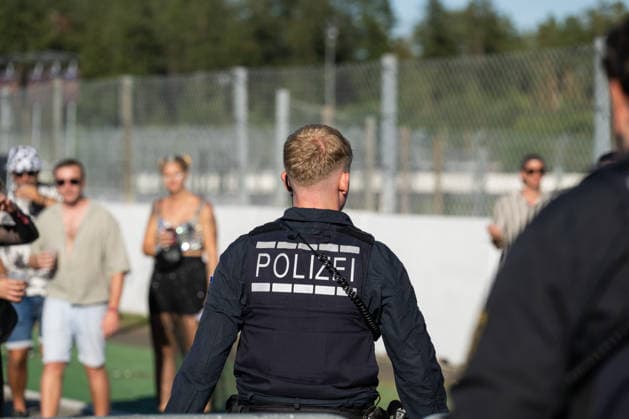 A police officer walks across the festival grounds at the Glücksgefühle Festival at the Hockenheimring in Hockenheim, Baden-Württemberg, Germany