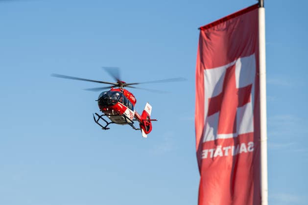 A Luftrettung rescue helicopter flies onto the festival grounds at the Glücksgefühle Festival at the Hockenheimring in Hockenheim, Baden-Württemberg, Germany
