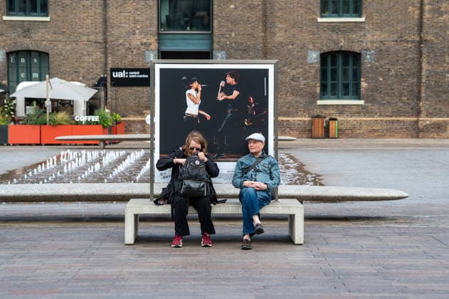 Amy Winehouse in Focus Free Exhibition Kings Cross in London, UK - 9 SEP2026. Two visitors seen sitting in front of one of the portraits of the late singer in Granary Square, King’s Cross. Visitors view ‘Amy Winehouse: In Focus’, a free outdoor photography exhibition at Granary Square and King’s Boulevard in King’s Cross, London. The exhibition features defining and previously unseen photographs of the late singer, offering an intimate portrait of her life and career and marking 20 years since the release of her acclaimed album ‘Back to Black’. The exhibition runs from 1 September to 15 October 2026. London United Kingdom Copyright: xJamesxWilloughbyx xSOPAxImagesx JWILLOUGHBY_3335
