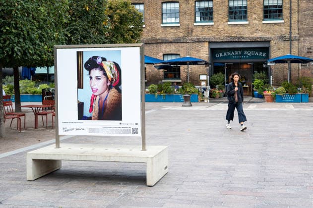 Amy Winehouse in Focus Free Exhibition Kings Cross in London, UK - 9 SEP2026. A woman seen walking past a portrait of Amy Winehouse displayed as part of the ‘Amy Winehouse. Visitors view ‘Amy Winehouse: In Focus’, a free outdoor photography exhibition at Granary Square and King’s Boulevard in King’s Cross, London. The exhibition features defining and previously unseen photographs of the late singer, offering an intimate portrait of her life and career and marking 20 years since the release of her acclaimed album ‘Back to Black’. The exhibition runs from 1 September to 15 October 2026. London United Kingdom Copyright: xJamesxWilloughbyx xSOPAxImagesx JWILLOUGHBY_3340
