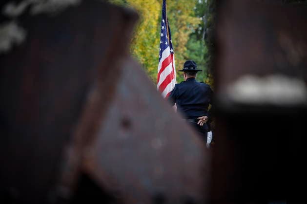 September 11, 2026, Winnipeg, Mb, Canada: A US border service officer holds his flag in front of the remnants Twin towers beams as people participate in the 25th Annual 9 11 Memorial Service at the International Peace Garden in Boissevain, Man., Friday, Sept. 11, 2026. Winnipeg Canada  - ZUMAc35_ 20260911_zaf_c35_109 Copyright: xJohnxWoodsx