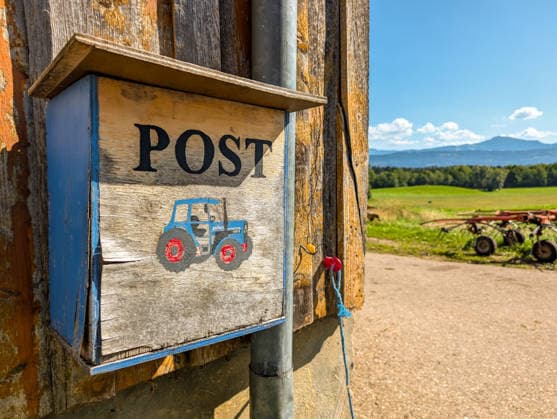 Allgäu, Bavaria, Germany - September 12, 2026: A homemade mailbox hangs on a farm in a rural area. The image symbolizes mail delivery, the mail service, and rural infrastructure, as well as the accessibility of remote farms.