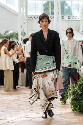 Models present creations from Adolfo Dominguez s Croma collection for spring-summer 2027 during Mercedes-Benz Fashion Week Madrid. Under the creative direction of Tiziana Domínguez, the Galician label, marking its 50th anniversary, remained faithful to its signature codes, showing pronounced asymmetry, scarves worked into both menswear and womenswear, sequins and textile appliques, alongside organic cotton denim dyed in tangerine tones and mini-pleated men s trousers. September 14,2026. (202609141024)