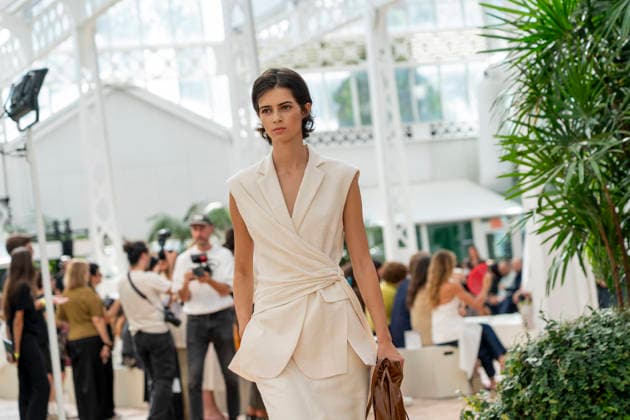 Models present creations from Adolfo Dominguez s Croma collection for spring-summer 2027 during Mercedes-Benz Fashion Week Madrid. Under the creative direction of Tiziana Domínguez, the Galician label, marking its 50th anniversary, remained faithful to its signature codes, showing pronounced asymmetry, scarves worked into both menswear and womenswear, sequins and textile appliques, alongside organic cotton denim dyed in tangerine tones and mini-pleated men s trousers. September 14,2026. (20260914826)