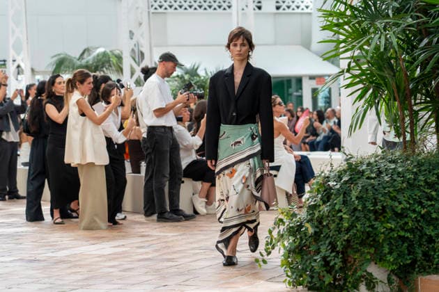 Models present creations from Adolfo Dominguez s Croma collection for spring-summer 2027 during Mercedes-Benz Fashion Week Madrid. Under the creative direction of Tiziana Domínguez, the Galician label, marking its 50th anniversary, remained faithful to its signature codes, showing pronounced asymmetry, scarves worked into both menswear and womenswear, sequins and textile appliques, alongside organic cotton denim dyed in tangerine tones and mini-pleated men s trousers. September 14,2026. (202609141021)