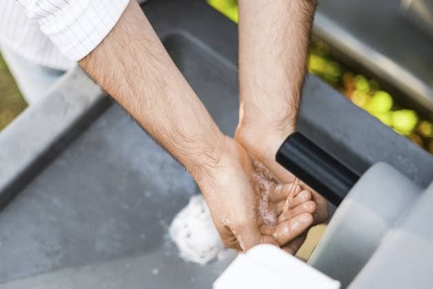 Nahaufnahme eines Mannes, der sich an einer tragbaren Waschbeckenstation im Freien unter fließendem Wasser die Hände wäscht und sich auf Körperpflege, Sauberkeit und sanitäre Einrichtungen konzentriert Close-up of man washing hands under running water at a portable outdoor sink station and focusing on personal care, cleanliness, and sanitation Copyright: imageBROKER KyryloxSyvun ibxiqx18688472.jpg ,model released, Symbolfoto ,property released