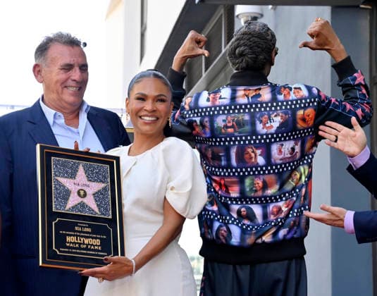 Actress Nia Long holds a replica plaque as she is joined by British film producer Graham King (L) and American rapper and actor Snoop Dogg during an unveiling ceremony honoring her with the 2,857th star on the Hollywood Walk of Fame in Los Angeles on Wednesday, September 16, 2026. Snoop Dogg s jacket displays stills from the many films Long has performed in.  LAP2026091622 JIMxRUYMEN