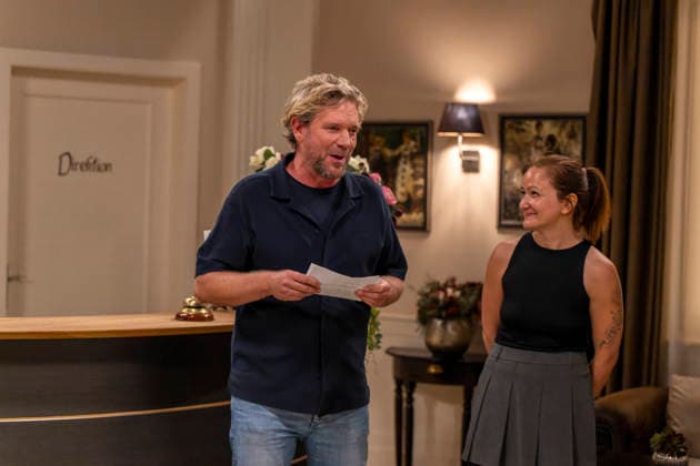 September 16, 2026, ARD telenovela *STURM DER LIEBE*, photo shoot for Season 23 on the film set in Munich, at Bavaria Film in Geiselgasteig, in the studio set of the fictional Hotel Fürstenhof. The new season premieres on November 4, 2026. From left: Producer Peter Proske Clayton with editor Lara Okamoto at the front desk on the