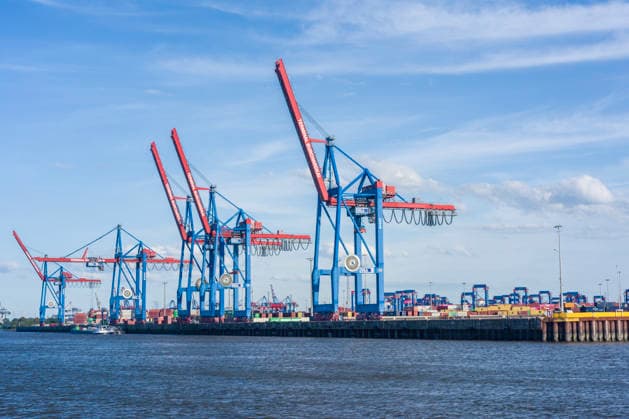 Large loading cranes are located at the terminal on the Elbe River in Hamburg, Germany. In the city of Hamburg