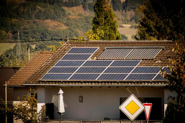 Photovoltaics and Solar Thermal Systems on a Residential Building in the Saarland Photovoltaic modules and solar thermal tube collectors on the roof of a residential building in Uchtelfangen, a district of Illingen in the Saarland, Germ