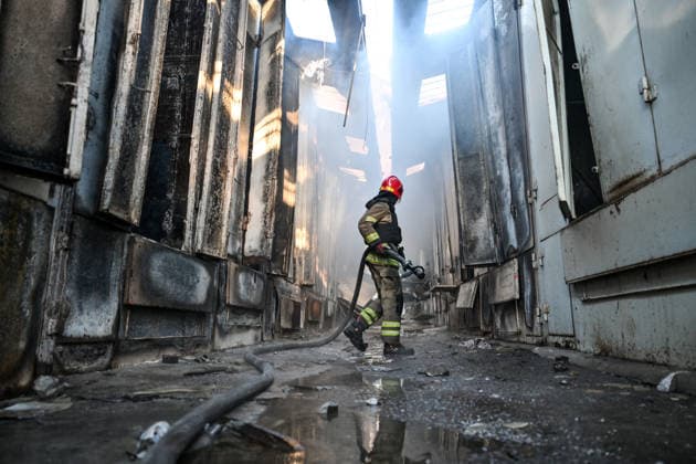 A State Emergency Service rescuer carries a fire hose as he walks along a smoke-filled passageway to extinguish a fire at the Central Clothes Market (Anholenko) in Zaporizhzhia, Ukraine, September 26, 2026. The market sustained significant damage in a Russian drone attack. (Photo by Dmytro Smolienko Ukrinform) Russian troops strike clothes market in Zaporizhzhia  Copyright: xDmytroxSmolienkox