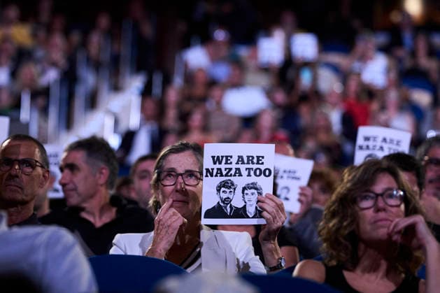 San Sebastian - Closing Ceremony Supporters attended Closing Ceremony Gala during 74th San Sebastian International Film Festival at Kursaal Palace on September 26, 2026 in Donostia San Sebastian, Spain People gather to witness the naza too gala closing on September 26, 2026. A hand holds a white poster with black text reading WE ARE NAZA TOO above two black-and-white illustrated portraits of two men, set against a blurred background of a crowd in dim, purple-toned lighting at the Gala Clausura San Sebastián. Photo by ABACAPRESS.COM Donostia San Sebastian Euskadi Spain  Copyright: xABACAx