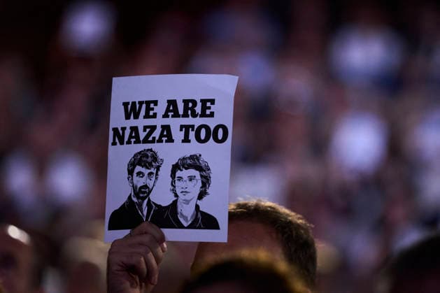 San Sebastian - Closing Ceremony Supporters attended Closing Ceremony Gala during 74th San Sebastian International Film Festival at Kursaal Palace on September 26, 2026 in Donostia San Sebastian, Spain People gather to witness the naza too gala closing on September 26, 2026. A hand holds a white poster with black text reading WE ARE NAZA TOO above two black-and-white illustrated portraits of two men, set against a blurred background of a crowd in dim, purple-toned lighting at the Gala Clausura San Sebastián. Photo by ABACAPRESS.COM Donostia San Sebastian Euskadi Spain  Copyright: xABACAx