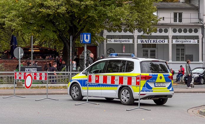 Hanover, Lower Saxony, Germany, Europe: A police patrol car secures the area around Waterloo during a soccer event. Barricades, visitors, and fans are visible in the background in front of the Waterloo beer garden. Stock image depicting police operations, security measures, soccer fans, public safety, and event management. Copyright: xAymanxAlahmedx