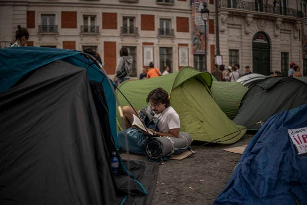Madrid Spain Demonstration Second Day A man reads a book among tents while camping overnight to protest evictions and housing speculation at Puerta del Sol in Madrid, Spain, on September 27, 2026. The ongoing demonstration, organized under the slogan Ni una Maricarmen mas ( Not one more Maricarmen ), targets the role of investment and vulture funds in the real estate market. Participants are calling for access to affordable housing and greater protection for tenants. Madrid Madrid Spain Copyright: xBrunoxTheveninx