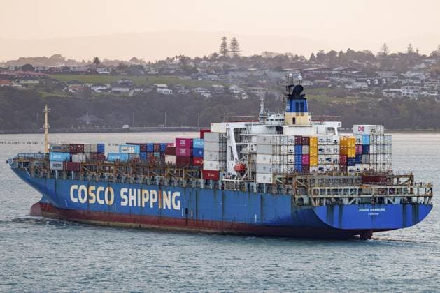 Das Containerschiff Cosco Hamburg überquert Aucklands Waitemat? Harbour in warmem Abenddämmerungslicht. Sein blauer Rumpf und die Cosco Shipping Lackierung fangen den goldenen Schimmer ein, als das Schiff das Containerterminal Ports of Auckland hinter den Küstenhügeln, Waitemata Harbour, Auckland, Neuseeland, verlässt The container ship Cosco Hamburg crosses Auckland s Waitemat? Harbour in warm dusk light, its blue hull and Cosco Shipping livery catching the golden glow as the vessel departs the Ports of Auckland container terminal past coastal hills, Waitemata Harbour, Auckland, New Zealand Copyright: imageBROKER DavidxRowland iblbmv19290140.jpg