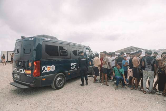 September 27, 2026, Ceuta, Ceuta, Spain: Migrants gather next to a Spanish National Police van in Ceuta. Thousands of migrants, most of them young Moroccan men, have been living in makeshift settlements in the Spanish North African enclave of Ceuta since a mass arrival at the end of July 2026 set off a migration and political crisis. Ceuta Spain  - ZUMAs392 20260927_zip_s392_007 Copyright: xFabianxSuspensivox