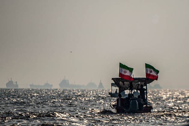 Commercial vessels are seen anchored offshore as small boats carrying members of Iran s paramilitary Basij Force take part in a military exercise along the Iranian coast overlooking the Strait of Hormuz, Iran, on Sunday on September 27, 2026. The exercise comes amid continuing regional tensions and heightened security measures around the Strait of Hormuz, one of the world s most strategically important waterways.  IRN2026092717 BehnamxTofighi
