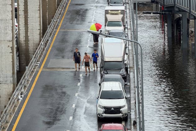 September 28, 2026, Bangkok, Bangkok, Thailand: People were walking by a few dozen cars stranded on Lat PhraoÃ¢â‚¬Seri Thai Flyover Road in Bangkapi, one of the most flooded areas in Bangkok since an active low-pressure system and monsoon have dumped nearly 300 millimetres (11.8 inches) of rain since the afternoon of September 24. Bangkok authorities have officially declared all 50 districts of the Thai capital as flood disaster areas following four straight days of severe rainfall. Bangkok Thailand - ZUMAw151 20260928_zip_w151_047 Copyright: xPatrickxChengzhixWangx