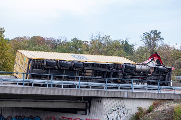 LKW kippt auf Autobahnverbindung um Zugmaschine hängt über Böschung Am 28.09.2026 kam es gegen 17:50 Uhr in Frankfurt am Main auf der A3 am Frankfurter Kreuz, auf der Verbindungsspur zur A5 in Richtung Darmstadt, zu einem schweren Unfall eines LKW-Sattelschleppers. Der mit einem 40-Fuß-Container beladene Lastzug geriet aus bislang unbekannter Ursache gegen die Betonschutzplanke und kippte auf die Seite, wobei die Zugmaschine erheblich beschädigt wurde und über die Böschung hing. Der Fahrer wurde leicht verletzt und in eine Klinik gebracht. Aus dem Fahrzeug ausgelaufene Betriebsmittel wurden von der Feuerwehr mit Bindemittel von der Fahrbahn entfernt. Die Bergungsarbeiten dauern an, die Auffahrt von der A3 auf die A5 in Richtung D
