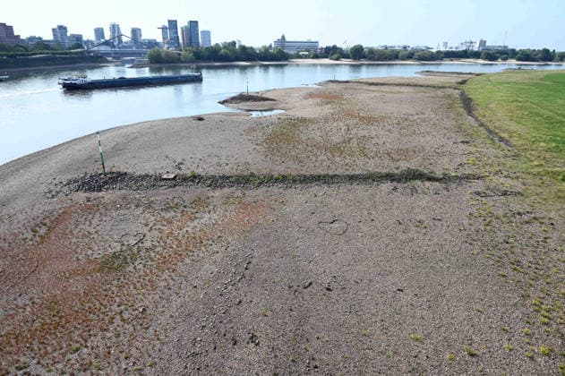 Low water levels in the Rhine have exposed a large sandbar; rocks and sand on the riverbank, as seen from the Rheinknie Bridge; a cargo ship sailing in the channel; low water levels in the Rhine near Düsseldorf; Düsseldorf on September 28, 2026,