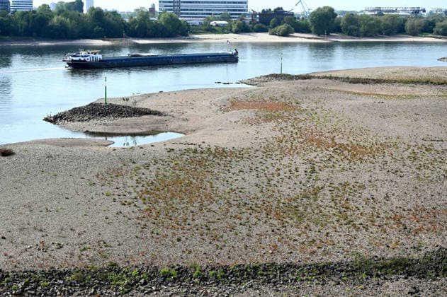 Low water levels in the Rhine have exposed a large sandbar; rocks and sand on the riverbank, as seen from the Rheinknie Bridge; a cargo ship sailing in the channel; low water levels in the Rhine near Düsseldorf; Düsseldorf on September 28, 2026,