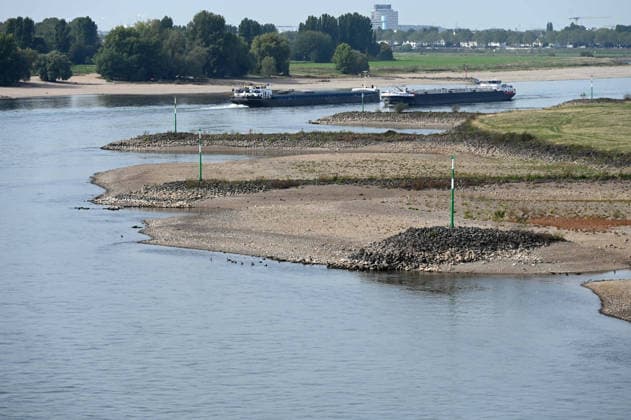 Low water levels in the Rhine have exposed a large sandbar; rocks and sand on the riverbank, as seen from the Rheinknie Bridge; a cargo ship sailing in the channel; low water levels in the Rhine near Düsseldorf; Düsseldorf on September 28, 2026,
