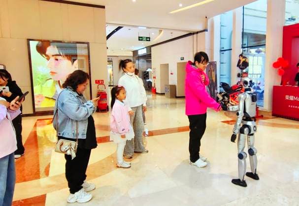 HARBIN, CHINA - SEPTEMBER 29: An AI humanoid robot interacts with customers at a shopping mall on September 29, 2026 in Harbin, Heilongjiang Province of China. The robot features flexible limb movements capable of dancing, shaking hands, waving, making heart gestures and engaging in voice communication with people.  Copyright: xVCGx 111670495814